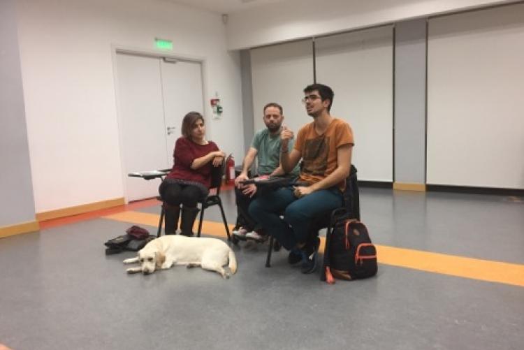 Ο Κωνσταντίνος, Ο Παναγιώτης, η Θάλεια και ο εκπαιδευόμενος σκύλος οδηγός από το Κέντρο Σκύλων Οδηγών Ελλάδος, Νίκη, κάθονται όλοι μαζί και συνομιλούν με το κοινό.