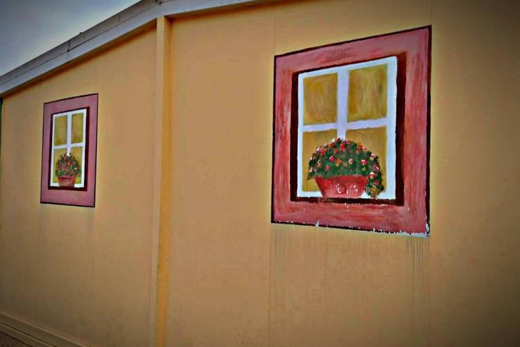 Δύο παράθυρα ζωγραφισμένα στον τοίχο ενός μικρού κτιρίου του σχολείου.