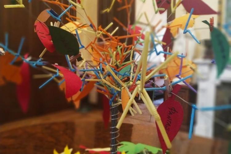 Πολύχρωμη κατασκευή δέντρου από καλαμάκια ποτηριών και κομμάτια χαρτονίου με χαρούμενα συνθήματα