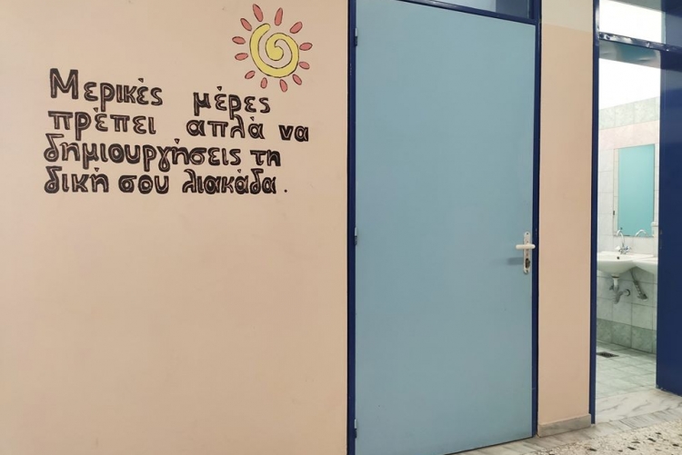 Τοίχος μπροστά από αναπηρική τουαλέτα που γράφει "Μερικές φορές πρέπει απλά να δημιουργήσεις την δική σου λιακάδα".